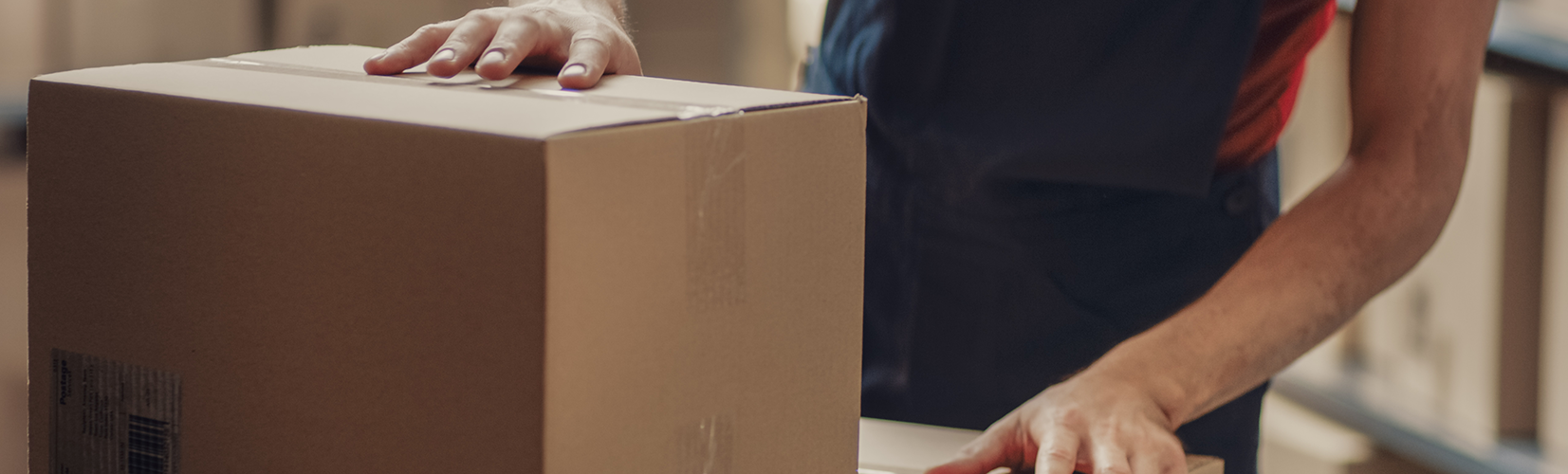 A person preparing a box package for shipment.