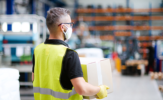 Person carrying box package inside warehouse