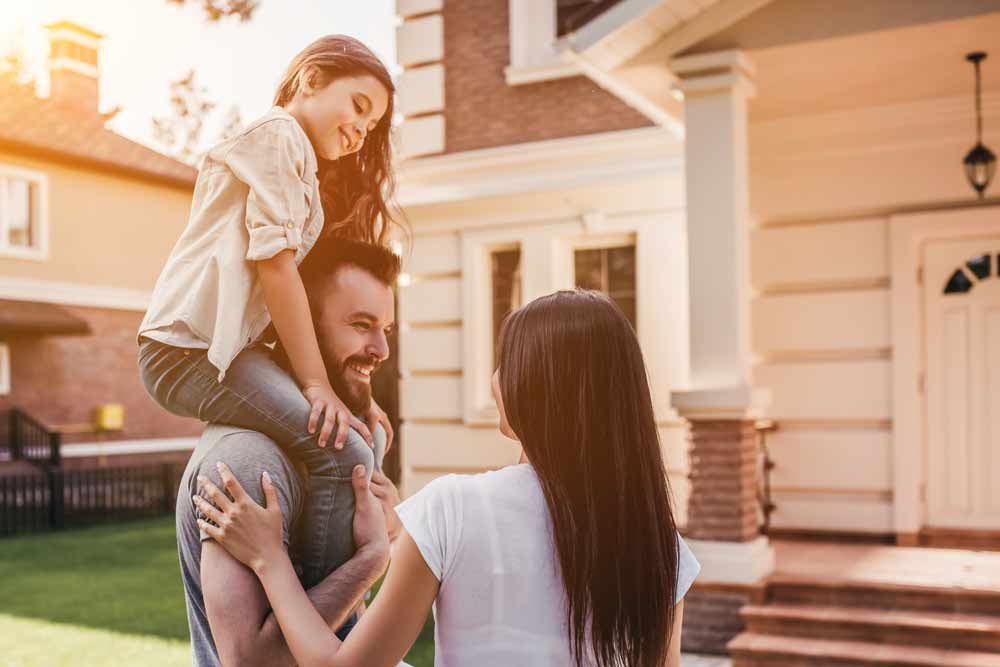 a happy family outside their home