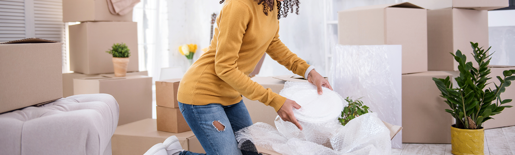 person moving out and packing belongings inside cardboard boxes