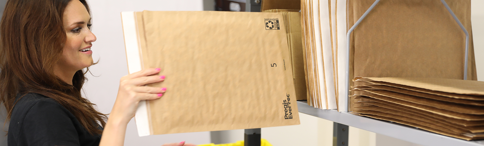 A woman places an Evertec Mailer on top of a pile of mail