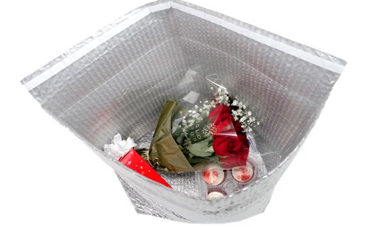 Boquet of red roses and a box of chocolates inside Pregis’ ThermaCycle Flex protective packaging