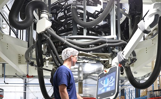 A person uses a machine system inside a warehouse.
