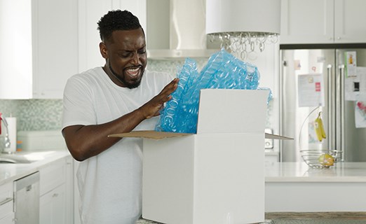 Person opening white box package containing HC Inspyre blue air cushions