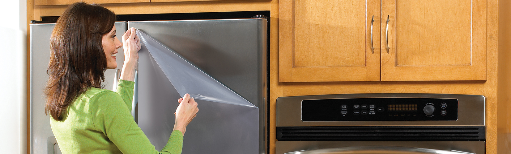 Lady removes surface protection film on new gray metallic colored refrigerator