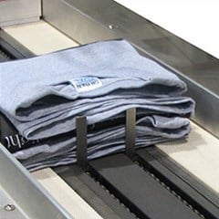 Apparel are being package by an automated packaging machine.
