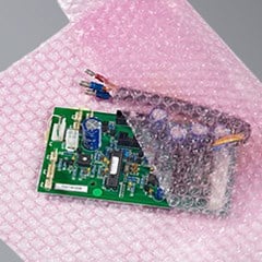 Pink colored anti static bubble cushioning is used to protect a small electrical component.