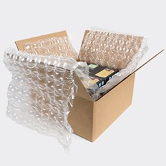 Image of a cardboard box with an item secured in clear inflated HC Barrier packaging, providing protection for shipping or storage.