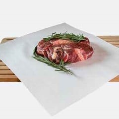 A piece of uncooked steak meat is placed on top of a butcher paper.
