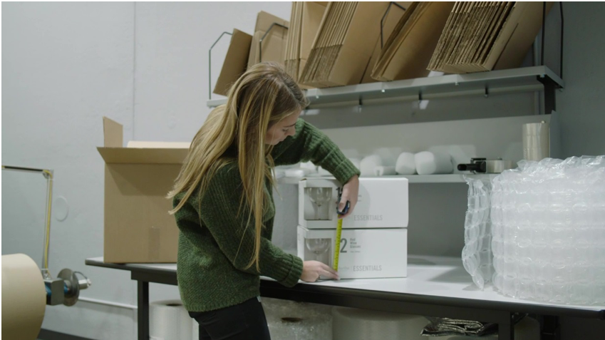 A packaging engineer is measuring two boxes piled on top of each other inside the Pregis IQ.